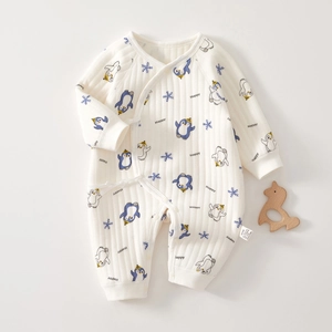 Detail of newborn white cotton romper with penguin prints and side ribbon tie design