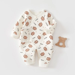 Macro detail of soft cotton newborn romper featuring brown bear prints and side-tie closure