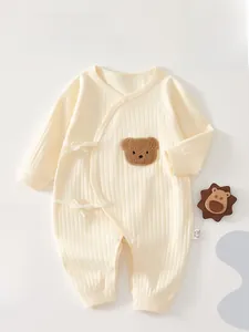 Détail de la barboteuse en coton côtelé pour bébé avec fermeture latérale et broderie
