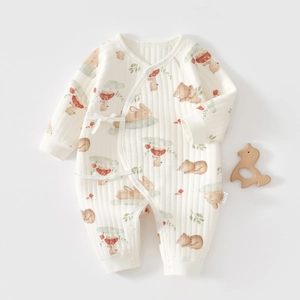 Detail of baby quilted romper with bear patterns and side-tie closure on light grey background