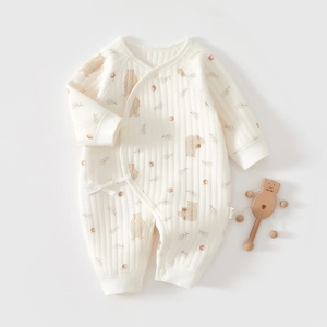 Macro detail of ribbed cotton baby romper featuring a cute brown bear print and side ties