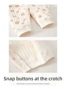 Detail of snap button closures on baby waffle romper with tomato pattern print
