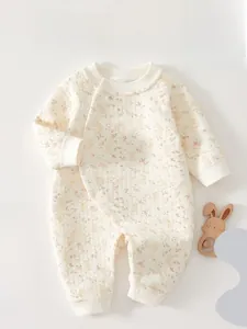 Close-up of quilted cotton baby romper featuring a delicate floral and rabbit pattern