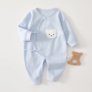 Détail d'un body bébé en coton bleu clair avec tissu côtelé doux et broderie d'ours