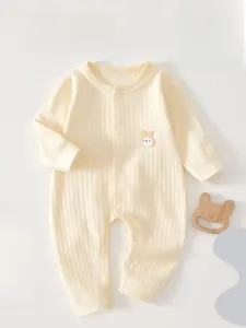 Detail of yellow ribbed cotton infant romper with cute rabbit embroidery and snap buttons