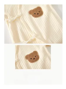 Détail de la barboteuse pour bébé avec tissu en coton côtelé et broderie d'ours brun