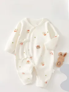 Close-up of cream baby cotton romper with rabbit and bear prints and side-tie closure