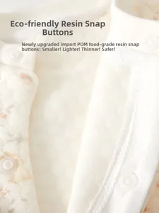 Detail of eco-friendly resin snap buttons on floral pattern baby quilted romper