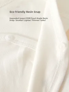 Detail of POM food-grade resin snap buttons on cream white newborn baby cotton bodysuit