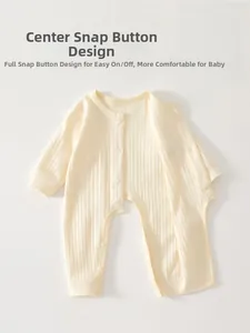 Close-up of cream ribbed cotton baby romper with durable white resin snap buttons