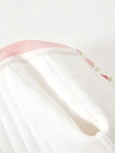 Detailansicht der flachen Nähte am weißen Baby-Body mit rosa elastischem Bund für Komfort