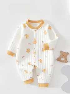 Close-up of white padded baby romper featuring cute bear prints and button closure