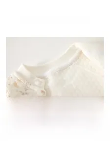 Detail of quilted thermal baby romper with padded fabric and floral print cuffs
