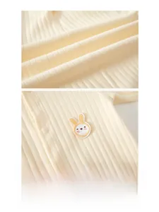 Detail of warm beige ribbed cotton baby romper featuring cute rabbit embroidery and snaps