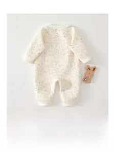 Detail of baby quilted romper with floral print and ribbed cuffs on light gray background