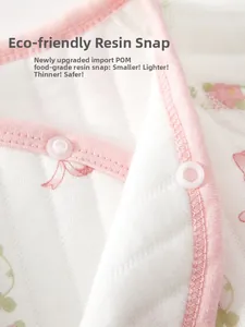 Macro detail of safe resin snap buttons on cotton floral baby bodysuit with pink edges