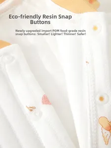 Detail of baby cotton romper with soft orange piping and secure POM resin snap buttons