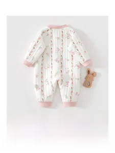 Detail eines Baby-Stramplers aus Baumwolle mit rosa Hasen- und Blumenprints und Bündchen