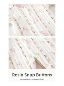 Detail der rosa Harzdruckknöpfe an einem gesteppten Baby-Strampler mit Kaninchenmuster