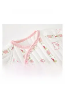 Detail of baby quilted cotton romper showing pink floral pattern and soft round neckline