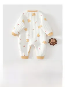 Close-up of baby quilted jumpsuit featuring cute cartoon bear prints and yellow ribbed cuffs