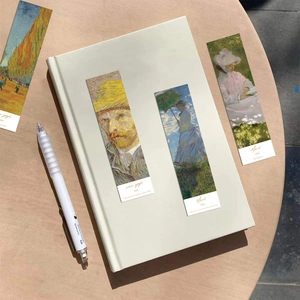 Detail of vintage art bookmarks featuring Van Gogh and Monet paintings on a desk