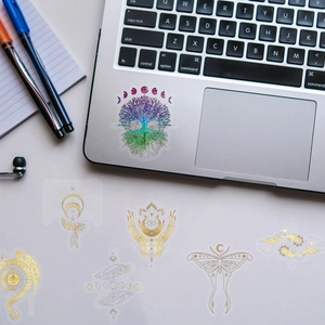 Detail of colorful laser PET stickers with mystical patterns on a laptop surface