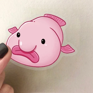 Pink cartoon blobfish PET sticker shown being held to demonstrate size and waterproof texture
