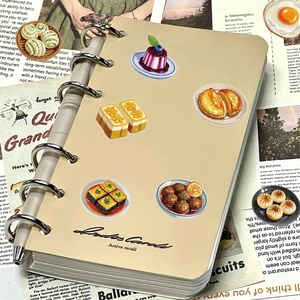 Detail of DIY journal with Chinese food stickers and silver metal pen on newsprint background