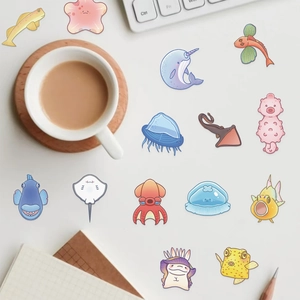 Flat lay of transparent sea creature PET stickers on desk with keyboard and notebook