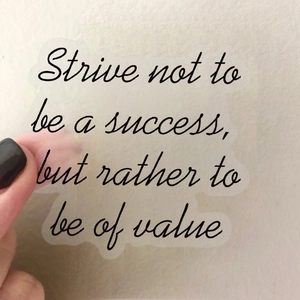 Close-up of inspirational quote sticker with black cursive text on transparent film