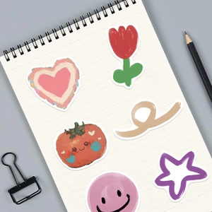 Close-up of hand-drawn cartoon bear and tulip stickers on a white grid notebook page
