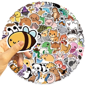 Main tenant un autocollant d'abeille montrant la taille parmi divers animaux mignons
