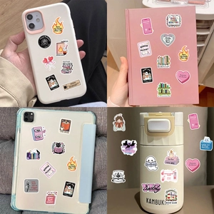 Detail of waterproof bookish stickers on laptop, phone case, and water bottle