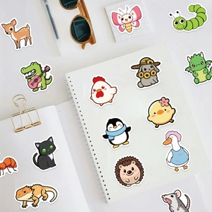 Variété d'autocollants d'animaux mignons et imperméables éparpillés sur un carnet de notes
