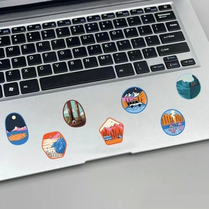 Outdoor camping stickers shown on silver laptop palm rest with retro nature illustrations