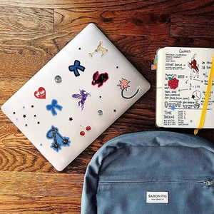 Close-up of cute cartoon stickers on a laptop and notebook for creative DIY decoration