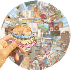 Detail of transparent PET sticker featuring an orange tabby cat curled on colorful cushions
