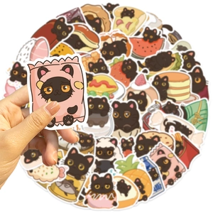 Close-up of waterproof black cat stickers with food motifs for DIY laptop and luggage decor