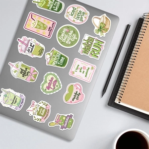 Detail of matcha-themed decorative stickers applied to a gray laptop lid surface