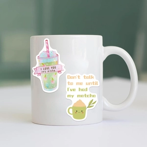 Close-up of cute matcha cartoon stickers on a white ceramic mug with creative puns