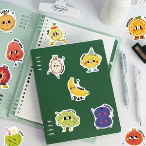 Cartoon fruit stickers with English names shown on a green notebook cover for learning