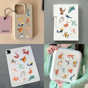Detailed view of mythical beast stickers applied on a phone case and laptop for DIY decor