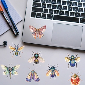 Detailed view of watercolor insect stickers on a laptop and desk for DIY decoration