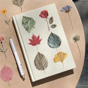 Detail showing realistic transparent plant stickers on notebook and wooden table