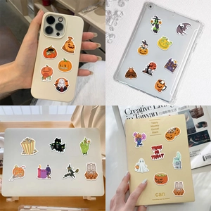 Detail showing waterproof Halloween stickers with pumpkin and ghost motifs on a laptop surface