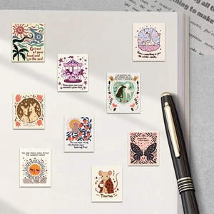 Close-up of artistic aesthetic stickers with inspirational quotes on notebook with pen