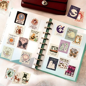 Detail of whimsical aesthetic stickers featuring cats and butterflies in a green planner