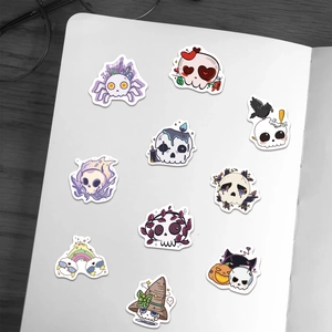 Detailed view of ten cute Kawaii Goth skull stickers on a minimalist notebook page