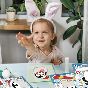 Detail of child's hands assembling cartoon penguin puzzle stickers for DIY creative play